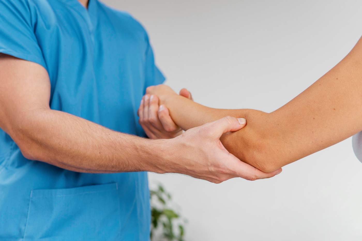 vista-laterale-del-terapista-osteopatico-maschio-che-controlla-il-movimento-dell-articolazione-del-gomito-del-paziente-femminile (1)