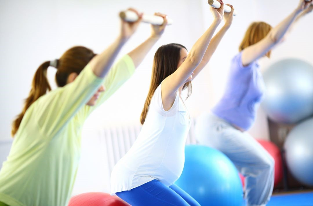 Tre donne incinte che svolgono ginnastica in gravidanza