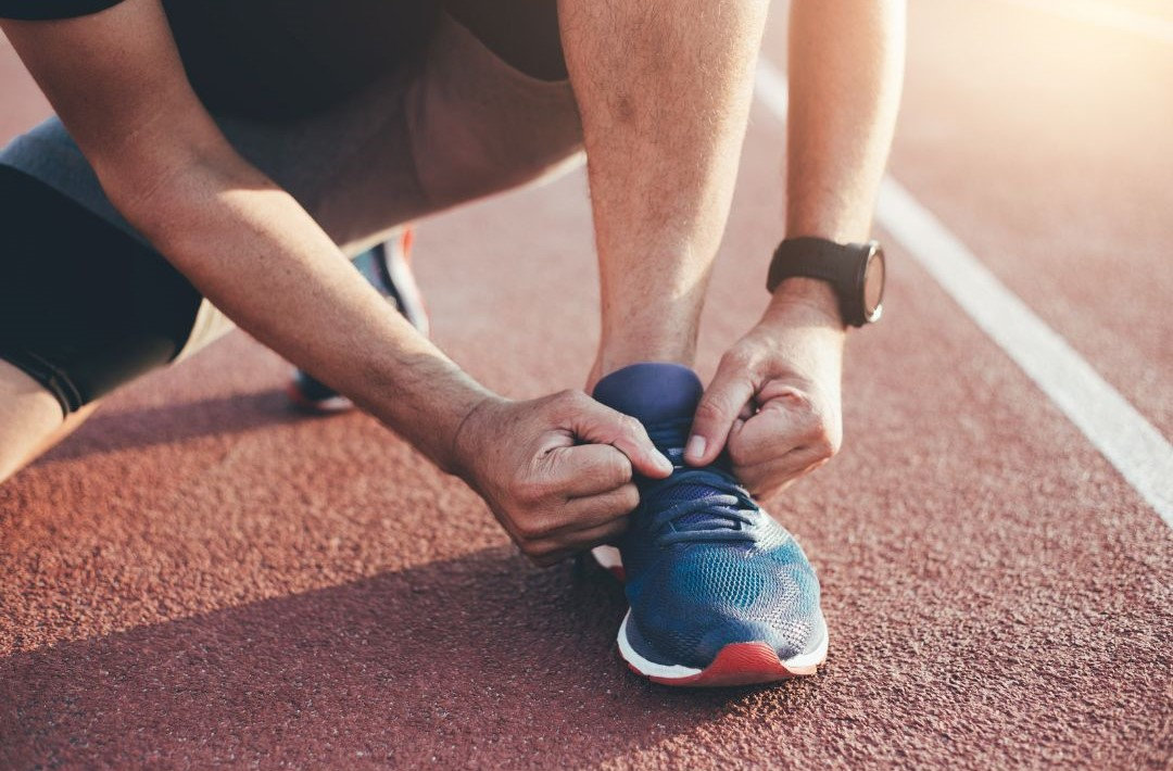 Atleta che si allaccia le scarpe prima di iniziare l'allenamento