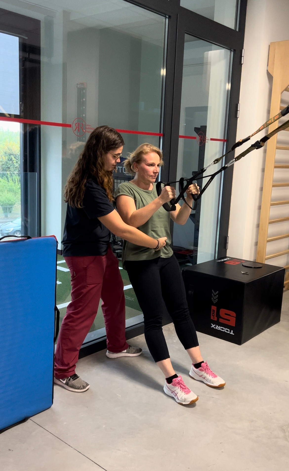 La nostra fisioterapista Sara segue una paziente durante una lezione di Functional Training con TRX all'interno della Sport Medicine Area CRR FisioFit
