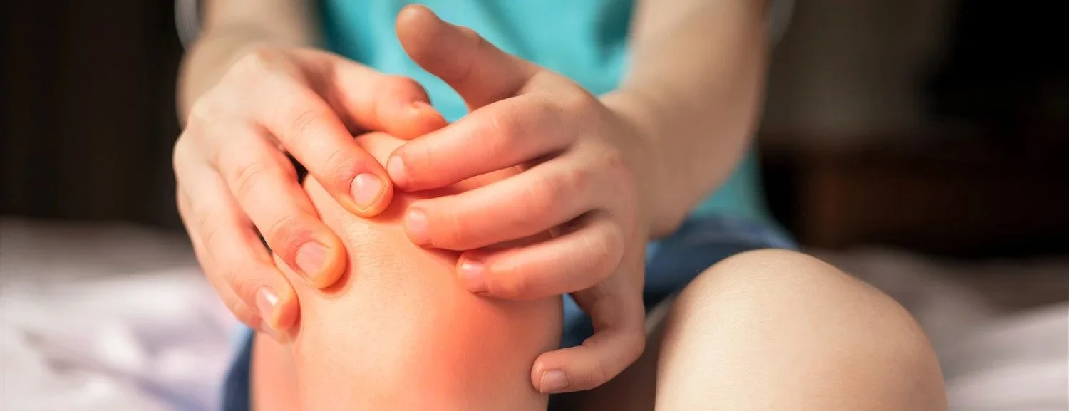 bambino si tocca ginocchio per dolore