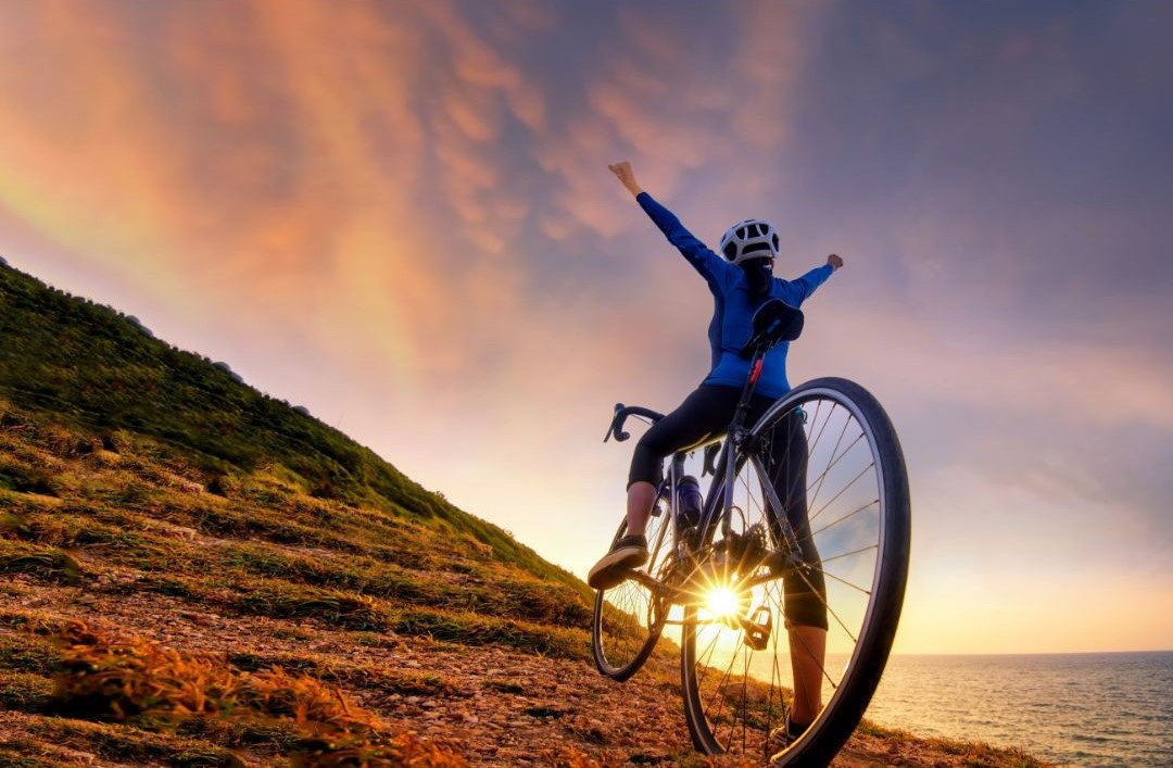 ciclista amatoriale con braccia al cielo in segno di gloria
