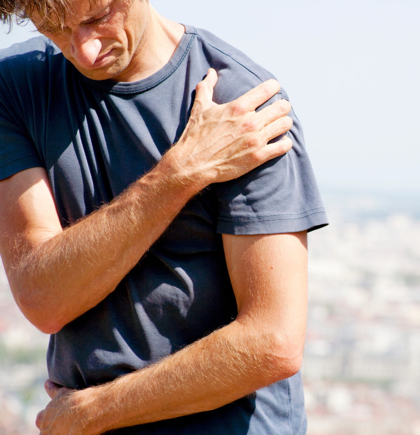 dolore alla spalla, uomo che si tocca la spalla per dolore