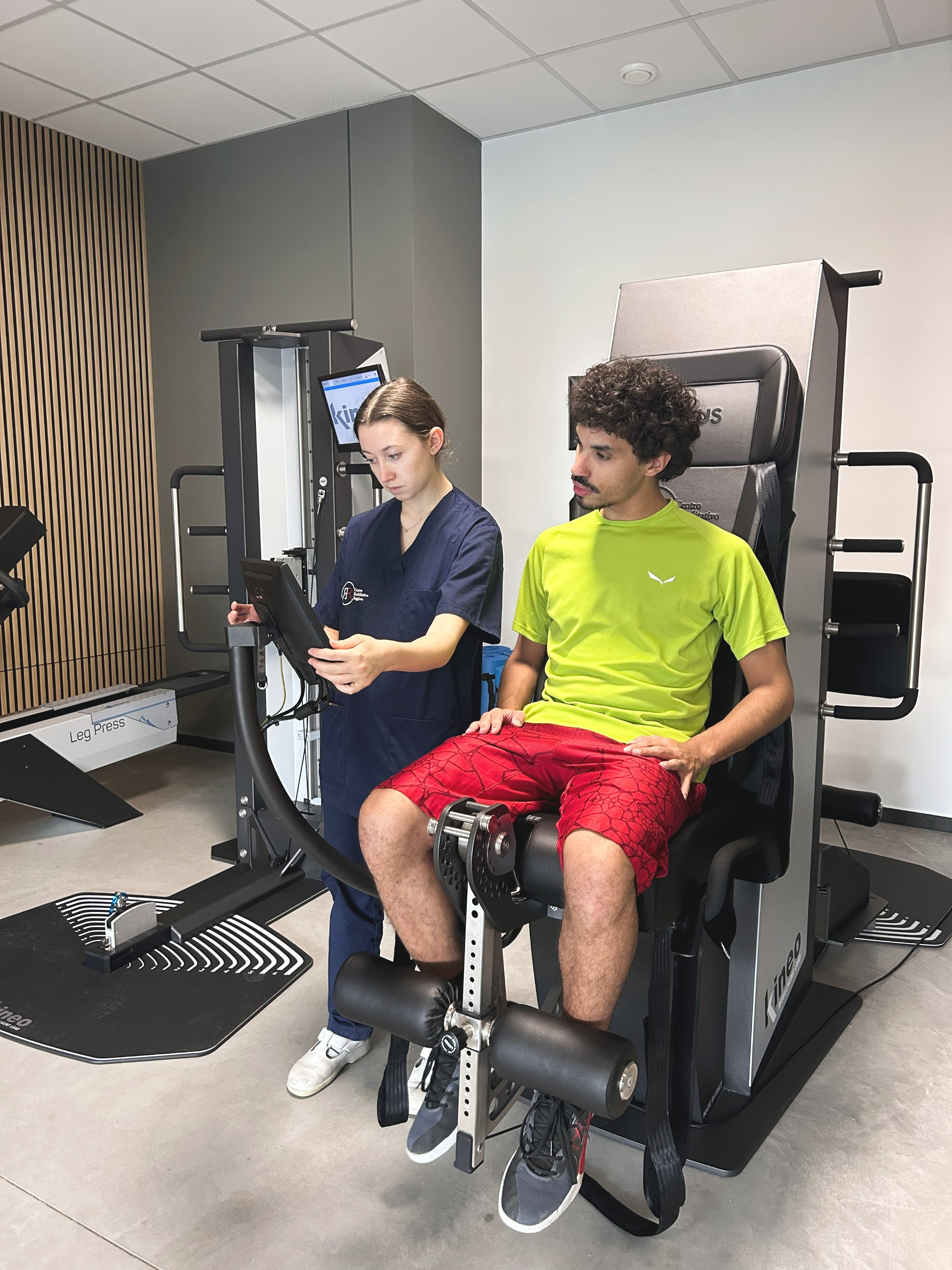 Un nostro macchinario Kineo per le gambe all'interno della Sport Medicine Area CRR FisioFit del Centro Riabilitativo Reggiano con la nostra fisioterapista ed un cliente