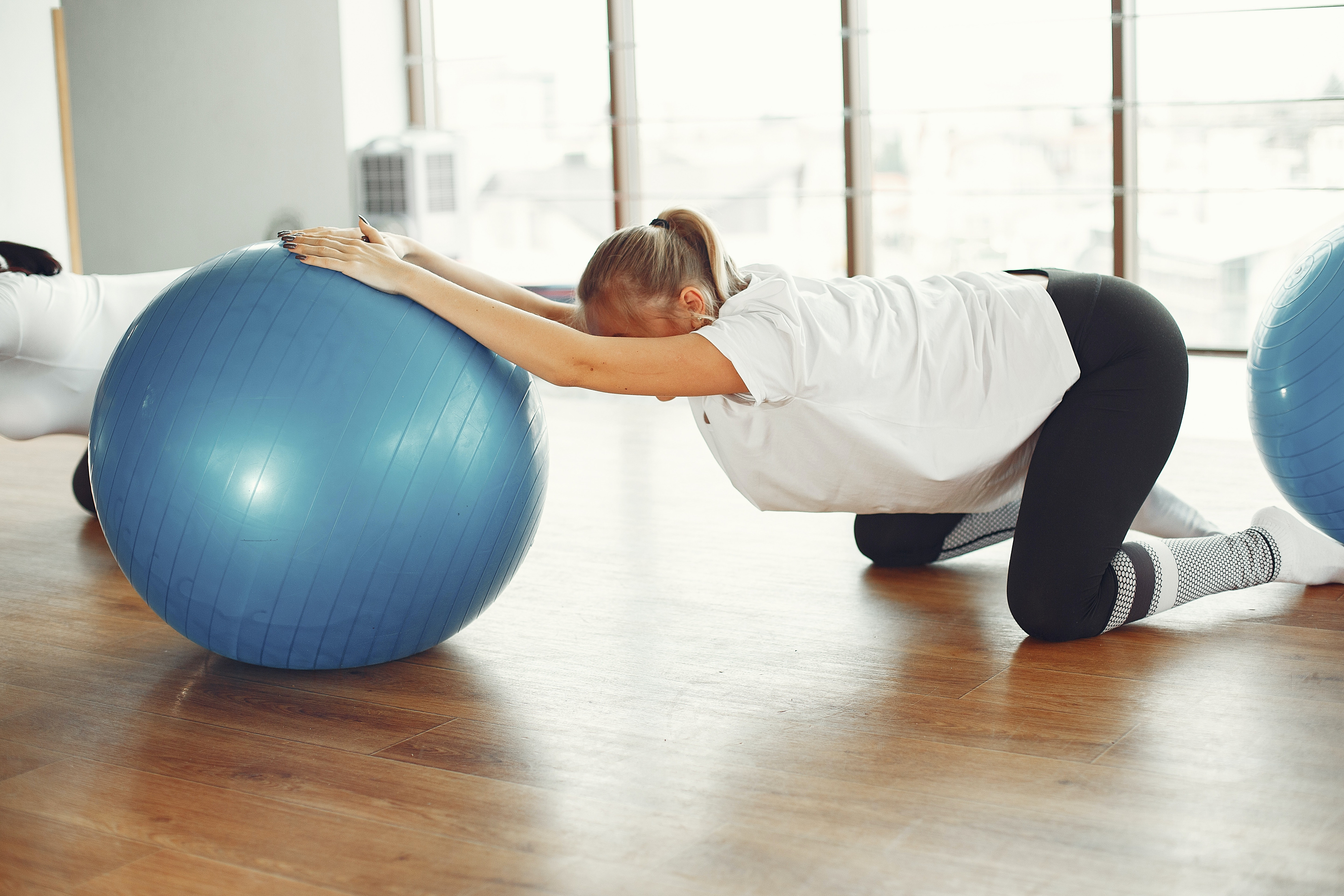 Neo-mamma che svolge esercizi di ginnastica con una fit ball
